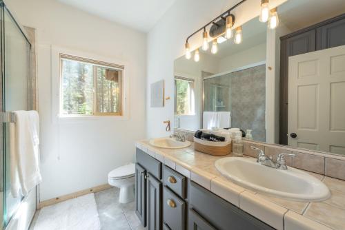 a bathroom with two sinks and a mirror and a toilet at Spacious 4BR Home 2 Decks with BBQ and Outdoor Furniture Walk to Lake Trails and More in Tahoma
