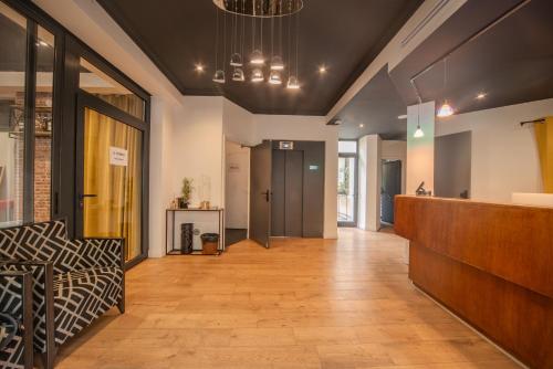 un hall de bureau avec une réception et un canapé dans l'établissement Casa Serena Paris Hôtel, à Paris