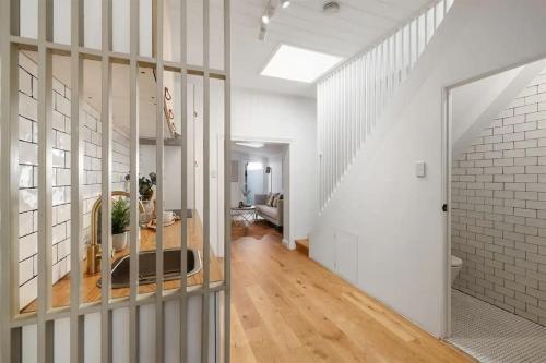 una sala de estar con paredes blancas y una escalera. en Balmain Central Cozy 3 bed house en Sídney