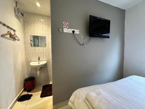 baño con cama, lavabo y TV en De UPTOWN Hotel @ Subang Jaya, en Subang Jaya
