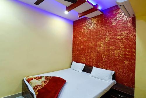 Habitación con cama con pared roja en Hotel Atithi Galaxy Kanpur Near Railway Station Kanpur - Wonderfull Stay with Family en Kānpur
