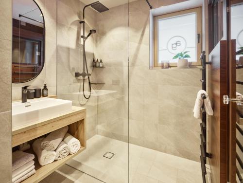 y baño con ducha y lavamanos. en Apart Galeon en Pettneu am Arlberg