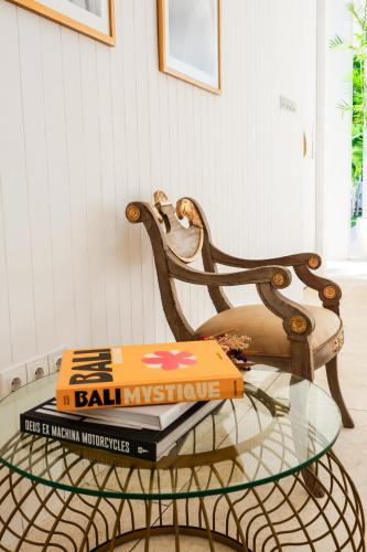 a glass table with books on top of a chair at Ria Uluwatu, Tropical Chic Hotel in Uluwatu