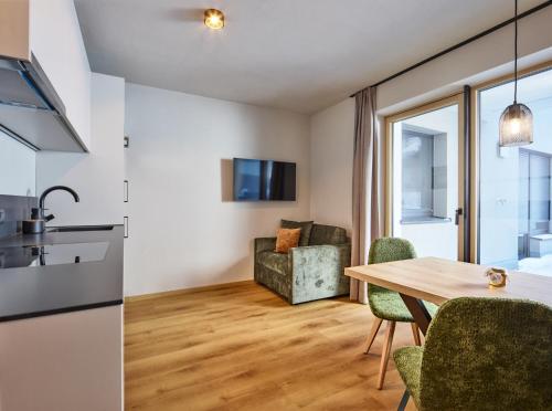 a kitchen and living room with a table and chairs at Apart Galeon in Pettneu am Arlberg