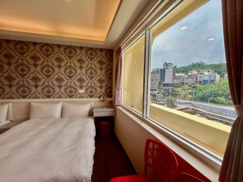 ein Hotelzimmer mit einem Bett und einem Fenster in der Unterkunft 夢海民宿 in Xiaoliuqiu
