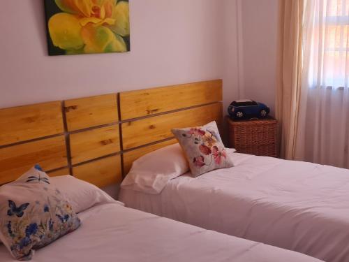 - une chambre avec 2 lits et une photo sur le mur dans l'établissement Mgrahamhouse, à Tacoronte
