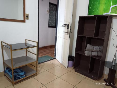 Zimmer mit einer Küche mit einem Kühlschrank und einem Regal in der Unterkunft Casa Qura Qura in Cochabamba