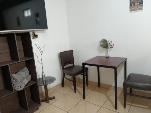 Habitación con mesa, 2 sillas, mesa y sidra de mesa en Casa Qura Qura, en Cochabamba