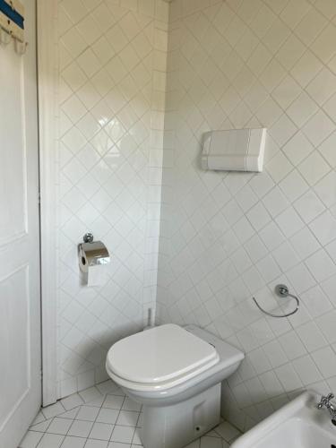 a white bathroom with a toilet and a sink at Lady Genny in Stintino