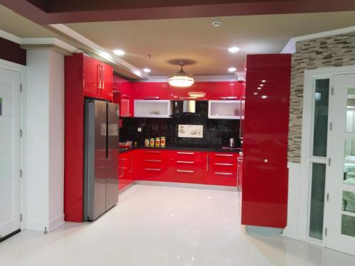 a red kitchen with red cabinets and appliances at Luxurious Penthouse La Grande Résidence with Home Theater & Netflix in Angeles