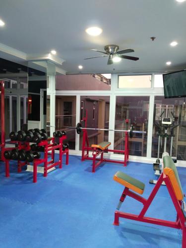 a fitness room with red chairs and a gym at Luxurious Penthouse La Grande Résidence with Home Theater & Netflix in Angeles