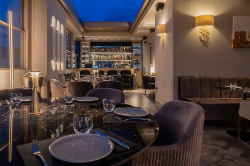 ein Restaurant mit Tischen und Stühlen und eine Bar in der Unterkunft Heritage Hill Hotel in Athen