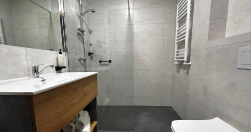 uma casa de banho com um chuveiro, um lavatório e um WC. em Hotel Igloo em Krotoszyn