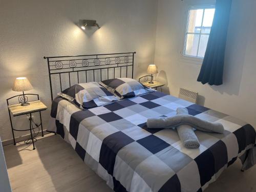 - une chambre avec un lit noir et blanc et 2 tables dans l'établissement La petite Jasse Camarguaise, à Gallargues-le-Montueux