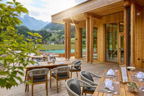 restauracja ze stołami i krzesłami na tarasie w obiekcie Gut Stiluppe - Good Life Hotel w Mayrhofen