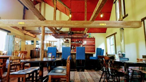 restauracja ze stołami i krzesłami oraz bar w obiekcie Bears House w mieście Furano