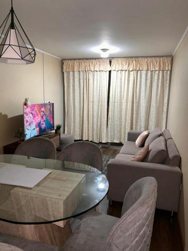 een woonkamer met een bank en een glazen tafel bij Departamento familiar con dos dormitorios en el centro de Lima in Lima