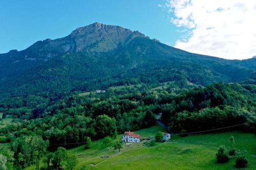 a house on a hill in front of a mountain at Fastuc B&B in Ponte nellʼAlpi