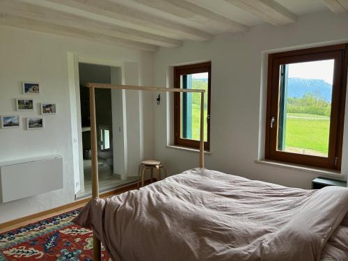 a bedroom with a bed and a large window at Fastuc B&B in Ponte nellʼAlpi