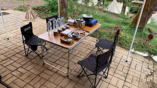 倫邦的住宿－Be Glamping Lembang，桌子和椅子,上面有锅和平底锅