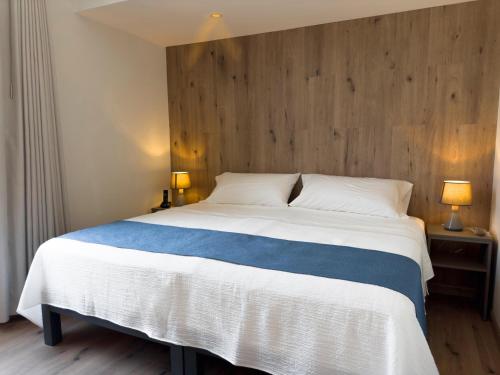 a bedroom with a large bed with a wooden wall at Hotel Casa costa in Mollendo