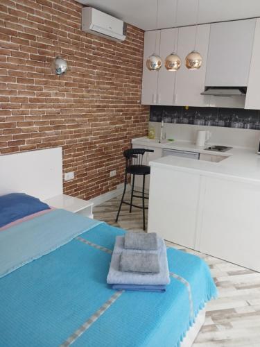 1 dormitorio con 1 cama azul y cocina en ЖК "Радужный берег" аэропорт 1 комнатная en Turksib