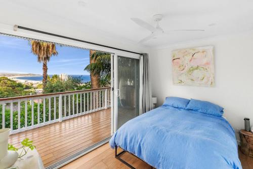 a bedroom with a bed and a balcony with a view at Villa Capriccio in Collaroy