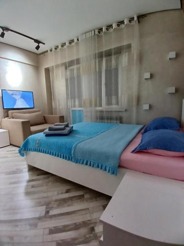 1 dormitorio con 1 cama grande y 1 sofá en ЖК "Радужный берег" аэропорт 1 комнатная en Turksib