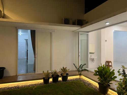 a living room with potted plants on the floor at Pita Asri Mansion in Padalarang