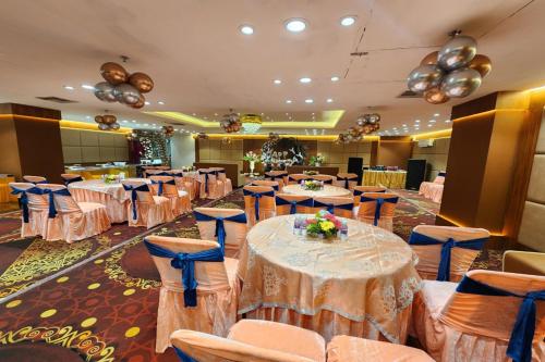 un salón de banquetes con mesas y sillas en una habitación en Hotel Mandakini Royale Near PVR Deep Cinema Hall Kanpur en Kānpur