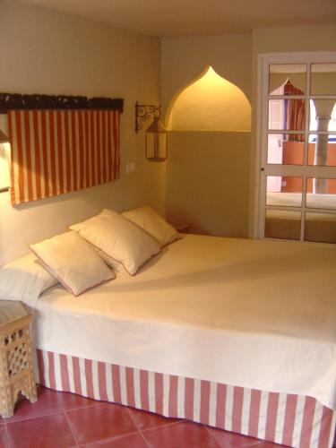 a large bed with two pillows in a bedroom at Beach Hotel Dos Mares in Tarifa