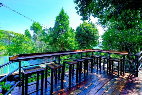 a deck with a bunch of tables and chairs at Woodcookies Guesthouse in Pangkor