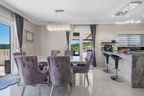 a kitchen and dining room with a table and chairs at Villa VERONICA with CINEMA PROJECTOR by the HEATED POOL and JACUZZI in Šibenik