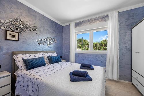 1 dormitorio con paredes azules y 1 cama con almohadas azules en Villa VERONICA with CINEMA PROJECTOR by the HEATED POOL and JACUZZI, en Šibenik