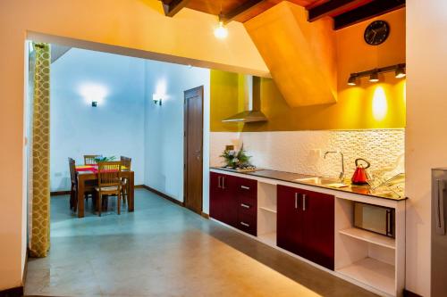 a kitchen with red cabinets and a dining room at Wintry Hills-Nuwara Eliya in Nuwara Eliya