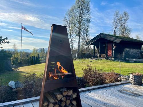 a fireplace with a fire in it in a yard at Cosy and Quiet Cabin with Sauna close to Hemsedal in Lykkja