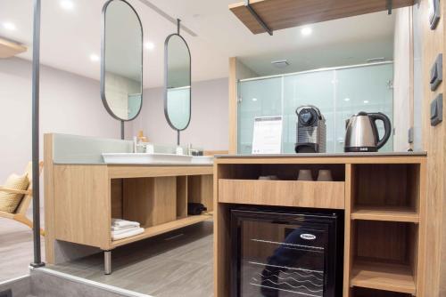 W łazience znajduje się umywalka i lustro. w obiekcie Hotel Jiji Plus w mieście Ch'ai-ch'iao-t'ou