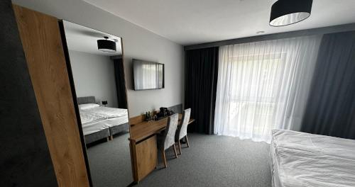um quarto com uma cama, uma secretária e um espelho em Hotel Igloo em Krotoszyn