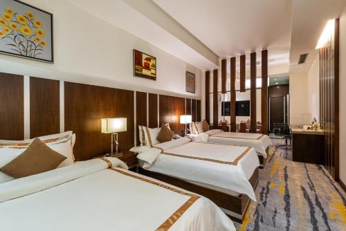 a hotel room with three beds and a bathroom at Sulaf Luxury Hotel in Amman