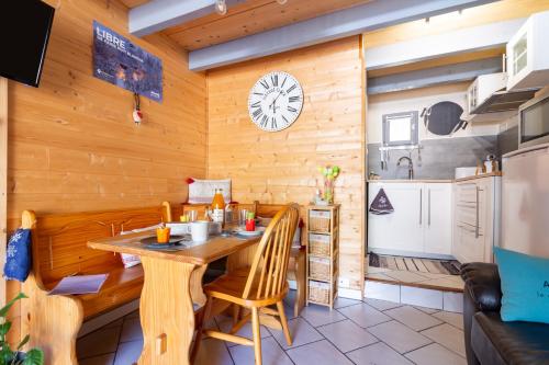 eine Küche mit einer Holzwand mit einem Tisch und Stühlen in der Unterkunft Chalet en Castel in Ax-les-Thermes