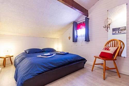 sypialnia z łóżkiem, krzesłem i oknem w obiekcie Chalet en Castel w mieście Ax-les-Thermes