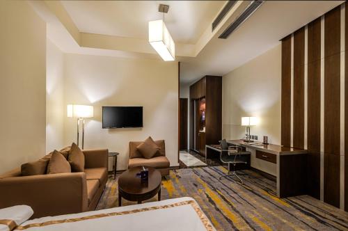 a hotel room with a couch and a desk at Sulaf Luxury Hotel in Amman