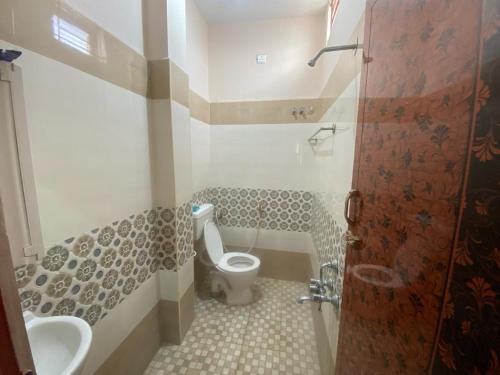 uma casa de banho com um WC e um lavatório em Samraj Stays em Coimbatore