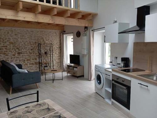 une cuisine et un salon avec laveuse et sécheuse dans l'établissement L'évidence 2 à 4 personnes, à La Jaudonnière