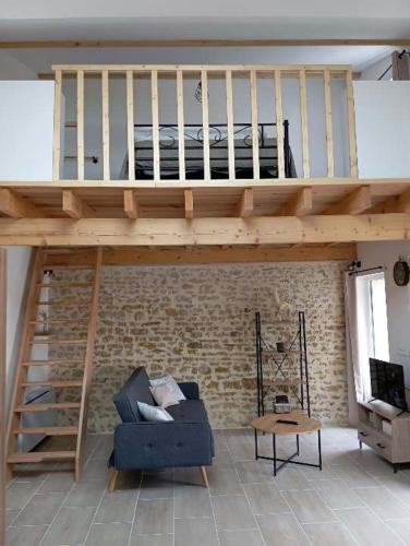 - un salon avec une mezzanine et un canapé bleu dans l'établissement L'évidence 2 à 4 personnes, à La Jaudonnière