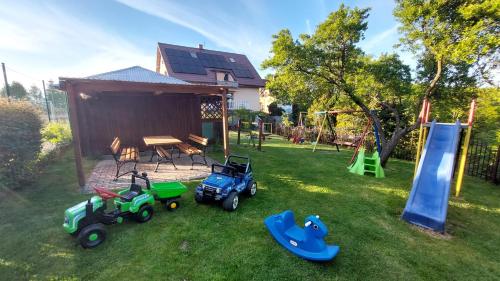 un patio con tractores de juguete y un parque infantil en Na Wzgórzu, en Połchowo