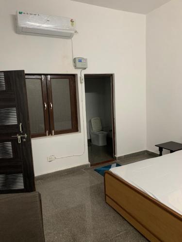 a room with a bed and a bathroom with a toilet at Shree Hari Kripa Dham in Jait