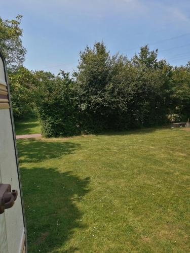 une vue d'une cour depuis la fenêtre d'une voiture dans l'établissement Camping à la ferme de la tournerie, à Raids