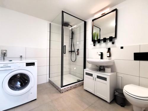 a white bathroom with a washing machine and a sink at BohnApartments - Design Suiten Am Markt - Vollausstattung - WLAN - Zentrum - Vollausstattung in Ilmenau