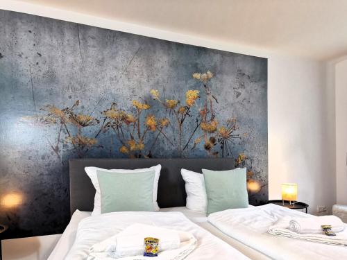 a bedroom with a painting on the wall at BohnApartments - Design Suiten Am Markt - Vollausstattung - WLAN - Zentrum - Vollausstattung in Ilmenau